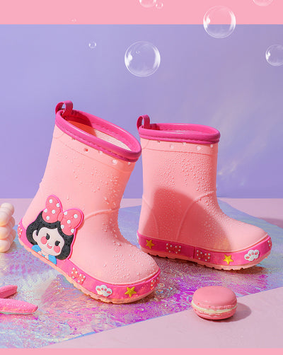 Bright yellow children's rain boots with a green cartoon dinosaur design and orange trim, held by hands. - Image 25
