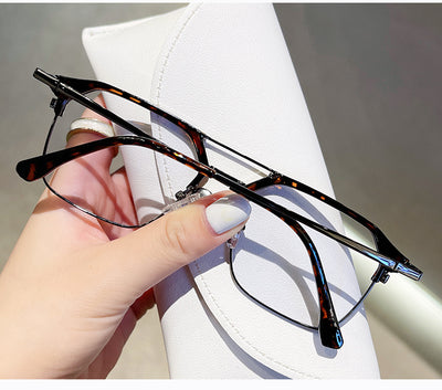 Anti-blue light glasses with a sand black and silver double beam frame, held against a white case. - Image 18