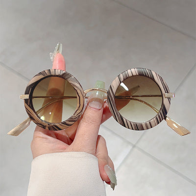 Small frame oval fashion sunglasses with black frames and vibrant orange lenses, held by a hand. - Image 2