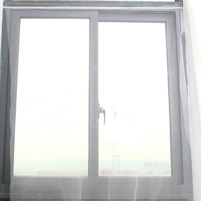 White self-adhesive mosquito screen applied to a gray window frame, offering clear visibility to the outside.