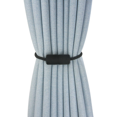 Black cylindrical magnetic curtain tieback holding a light blue pleated curtain, against a clean white background. - Image 9