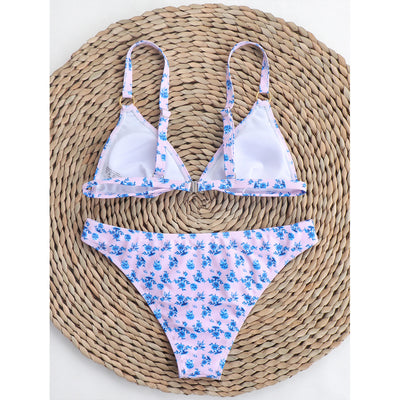 Woman smiling in a white bikini with blue floral print, triangle top, and briefs bottoms, on a sunny beach. - Image 40
