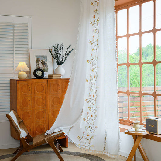 White semi-sheer curtain with brown botanical embroidery and white tassels, draped over a small wooden table. - Image 14