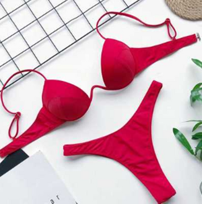 White two-piece bikini set with a push-up top and thong bottom, made of polyester, laid flat on a white surface. - Image 11