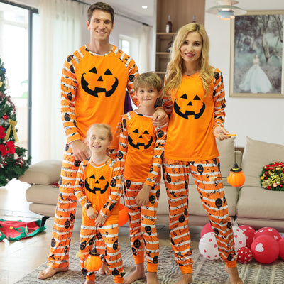 Family of four wearing matching orange and black Halloween pajamas with jack-o'-lanterns and striped patterns. - Image 5
