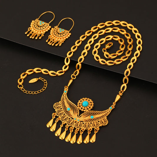 Gold-toned necklace and dangle earrings set with filigree water droplet design, turquoise accents, and tassel charms.