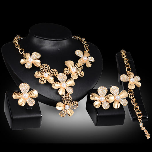 Gold-tone four-piece jewelry set with flower motifs, featuring a necklace, bracelet, ring, and earrings, all with faux pearls and clear rhinestones. - Image 5