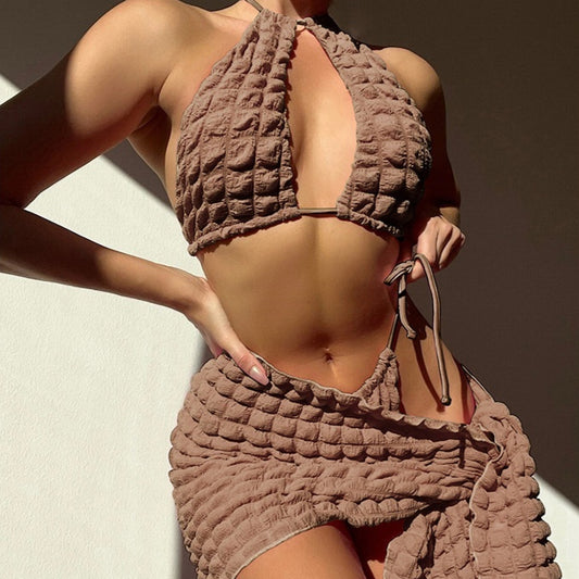 Light brown seersucker three-piece bikini swimsuit with a lace-up triangle top, tie-side bottoms, and a matching wrap skirt.