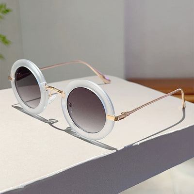 Small frame oval fashion sunglasses with black frames and vibrant orange lenses, held by a hand. - Image 23