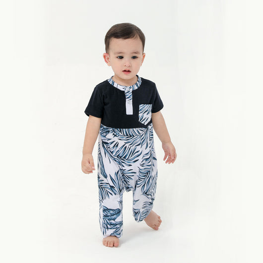 Young boy wearing a white short-sleeve t-shirt with blue tropical leaf print and a black chest pocket. - Image 16