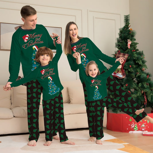 Family of four wearing matching green Christmas pajamas with "Merry Christmas" text and tree graphics.