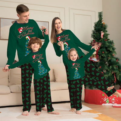 Family of four wearing matching green Christmas pajamas with "Merry Christmas" text and tree graphics.