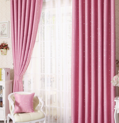 Blue star print curtains tied back to reveal sheer white curtains, in a bright room with a white chair. - Image 13