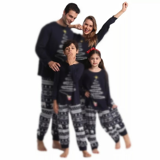 Family of four wearing matching red Christmas pajamas with a Christmas tree graphic and fair isle pattern.
