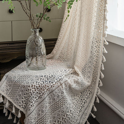 Translucent off-white American Country hollow crochet curtain with intricate patterns and tassel trim, draped by a window. - Image 2