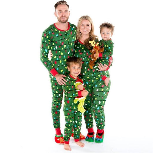 Woman wearing a green one-piece pajama suit with a colorful Christmas lights pattern and red cuffs, paired with festive slippers. - Image 5