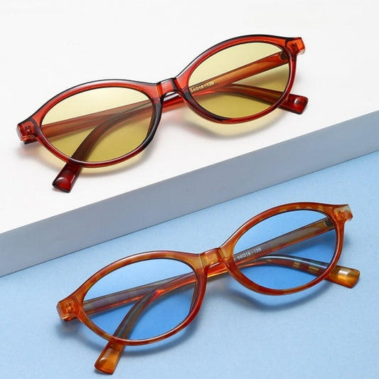 Retro fashion small frame sunglasses with translucent brown frames and yellow oval lenses, viewed from an angle.