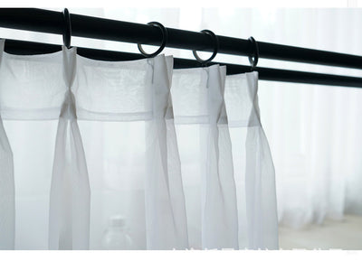 Sheer pink rod pocket curtain hanging on a black curtain rod, offering light transmission for a modern room. - Image 13