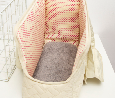 Cream quilted portable pet carrier with top handles, detachable shoulder strap, front pocket, and ventilation mesh. - Image 10