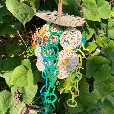 Colorful parrot chew toy made from natural fibers, featuring a woven ball, leaf-like accents, a bell, and a carabiner clip. - Image 14