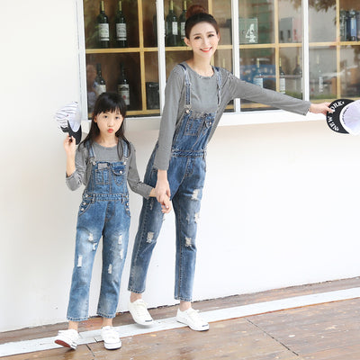 Mother and daughter wearing matching distressed denim overalls over black and white striped long-sleeve shirts. - Image 3