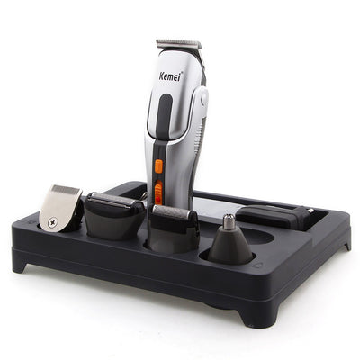 Kemei multi-function hair clipper set with silver and black body, orange buttons, and multiple interchangeable heads on a black charging base.