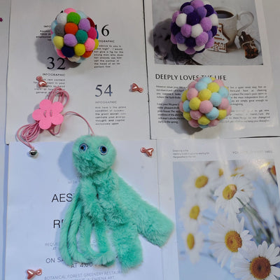 Purple plush cat teaser toy with googly eyes, elastic strings, and a pink flower attachment, resembling an octopus. - Image 3