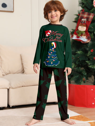Young girl wearing a dark green long-sleeved Christmas pajama set with a decorated tree and "Merry Christmas" text. - Image 6