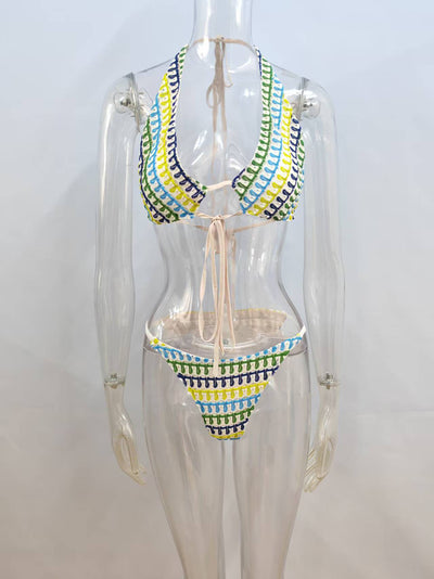 Woman in a blue, green, and yellow patterned halter bikini top and matching flowy sarong on a sunny beach. - Image 7