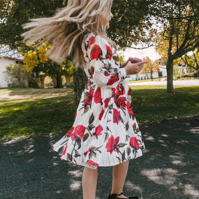 Mother and daughter in matching white dresses with red floral print, V-neck, long sleeves, and tie-waist. - Image 3