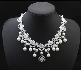 White lace choker necklace with dangling faux pearls and a central rhinestone pendant on a black jewelry bust. - Image 6