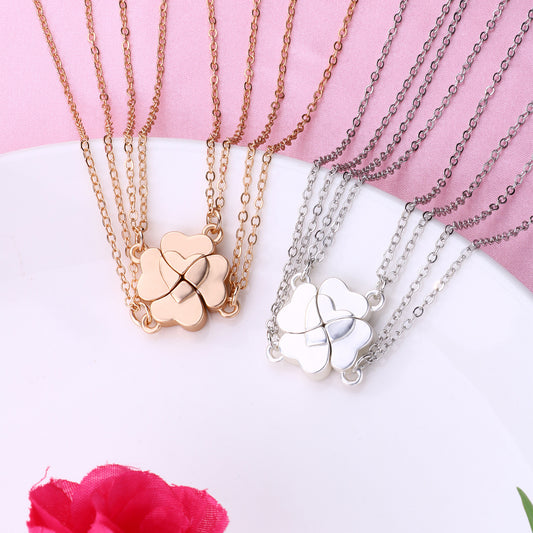 Four silver-colored necklaces, each with a half-heart charm that forms a four-leaf clover when combined, on pink satin. - Image 2