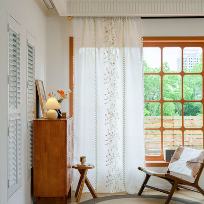 White semi-sheer curtain with brown botanical embroidery and white tassels, draped over a small wooden table. - Image 3