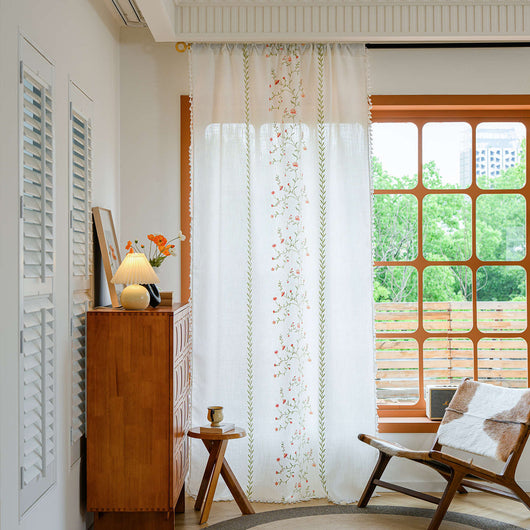White semi-sheer curtain with brown botanical embroidery and white tassels, draped over a small wooden table. - Image 3