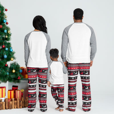 Woman wearing a white and grey long-sleeve Christmas pajama top with a plaid reindeer and patterned holiday pants. - Image 3