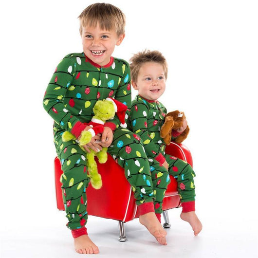 Woman wearing a green one-piece pajama suit with a colorful Christmas lights pattern and red cuffs, paired with festive slippers. - Image 8