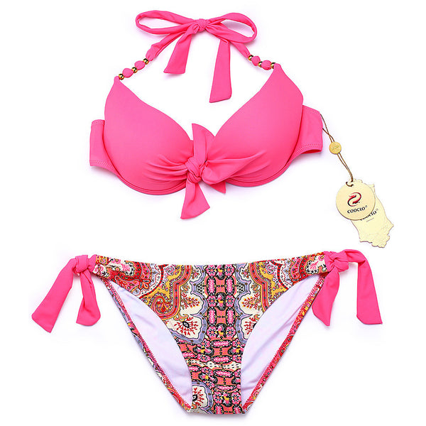 Hot pink halter bikini top with front knot and gold beads, paired with a colorful paisley tie-side bikini bottom.