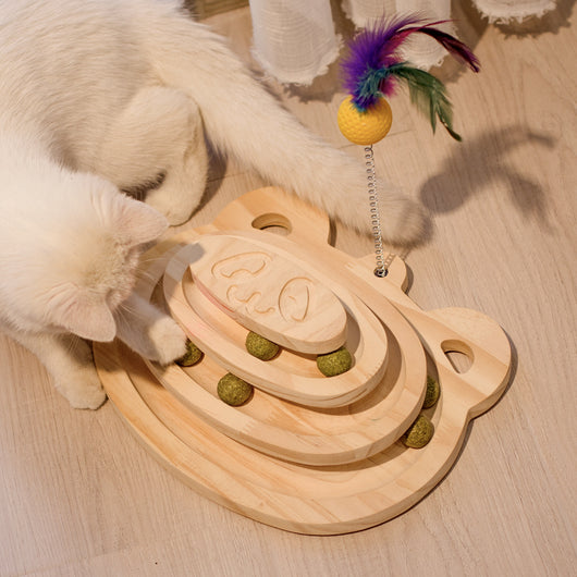 White cat playing with a wooden multi-level track toy featuring a spring-mounted yellow feather ball and a green catnip ball. - Image 16