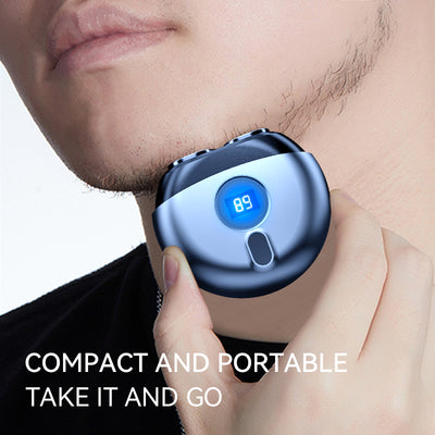 Dark gray mini electric razor with a circular design, featuring a small black display window and a silver trim. - Image 2