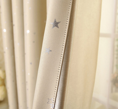 Blue star print curtains tied back to reveal sheer white curtains, in a bright room with a white chair. - Image 7