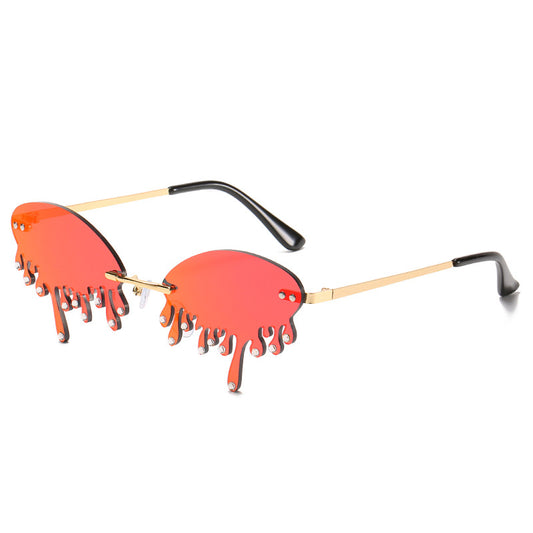 Rimless sunglasses with dark gray dripping liquid-shaped lenses, silver studs, and gold metal frames. - Image 2