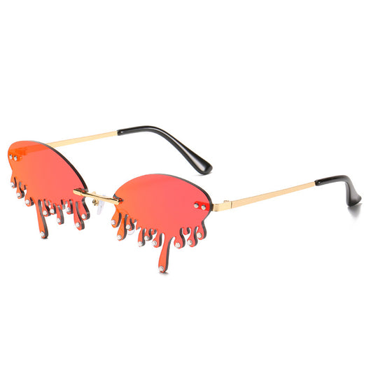 Rimless sunglasses with dark gray dripping liquid-shaped lenses, silver studs, and gold metal frames. - Image 2