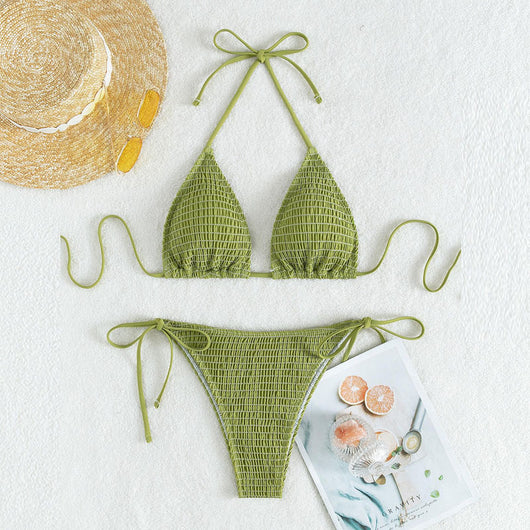 Women's lime green halter bikini with spaghetti straps and thong bottom, modeled outdoors against a blue sky.