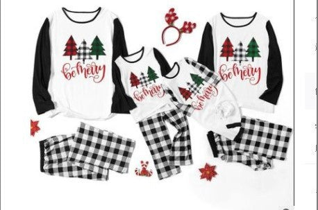 Matching family Christmas pajamas with white tops, black sleeves, buffalo plaid trees, and 'be merry' text. - Image 9