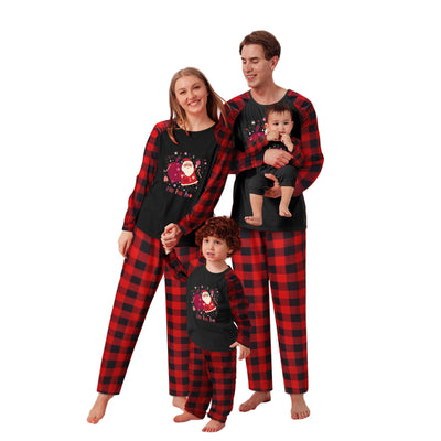 Family matching Christmas pajamas with black tops featuring a Santa graphic and red buffalo plaid sleeves and pants. - Image 13