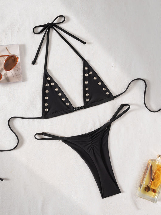 Black tie-front bikini swimsuit with silver grommets on the triangle top and a ruched thong bottom, laid flat. - Image 6