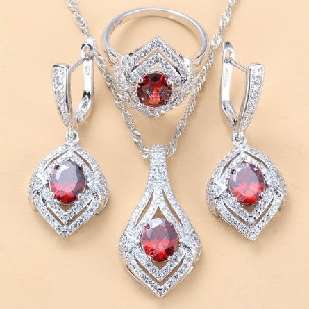 Silver-toned three-piece jewelry set with clear oval and round gems, including a necklace, dangle earrings, and a ring. - Image 10