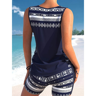 Women's navy blue tankini swimsuit with geometric pattern, criss-cross V-neck, and matching swim shorts. - Image 4
