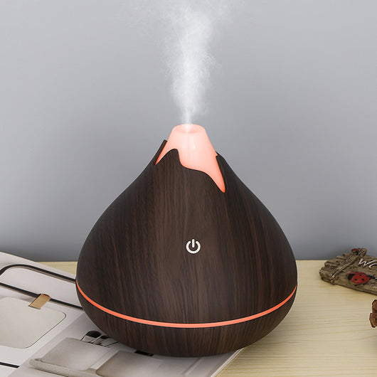 Teardrop-shaped aromatherapy humidifier with light wood grain finish, emitting mist and glowing with purple LED light. - Image 3