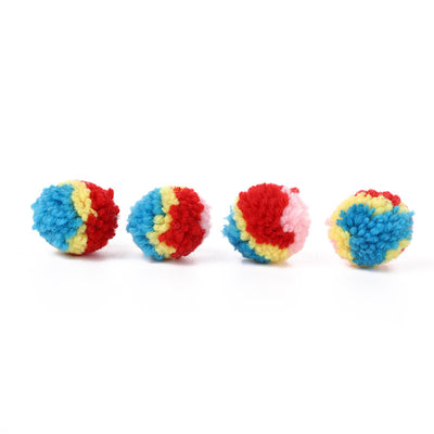 A hand holds a fluffy rainbow pom-pom ball toy, with another colorful ball in the background. - Image 2